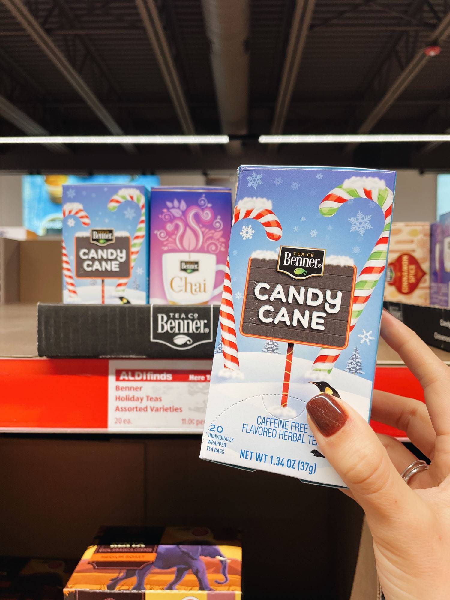 White hand holding box of candy cane tea