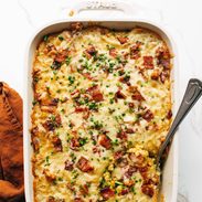 Corn casserole in a casserole dish with a serving spoon.