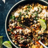 Elote quinoa salad in a bowl with cotija cheese and a fork