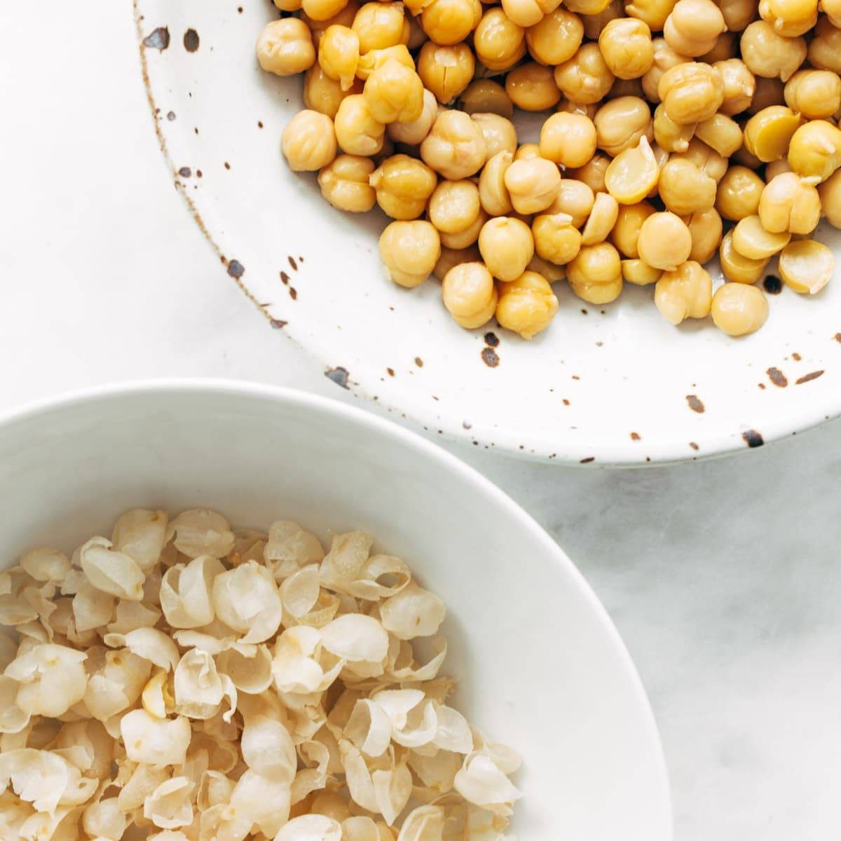 Chickpeas and skins in bowls.