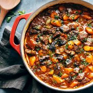 A pot of stew on a blue tablecloth.